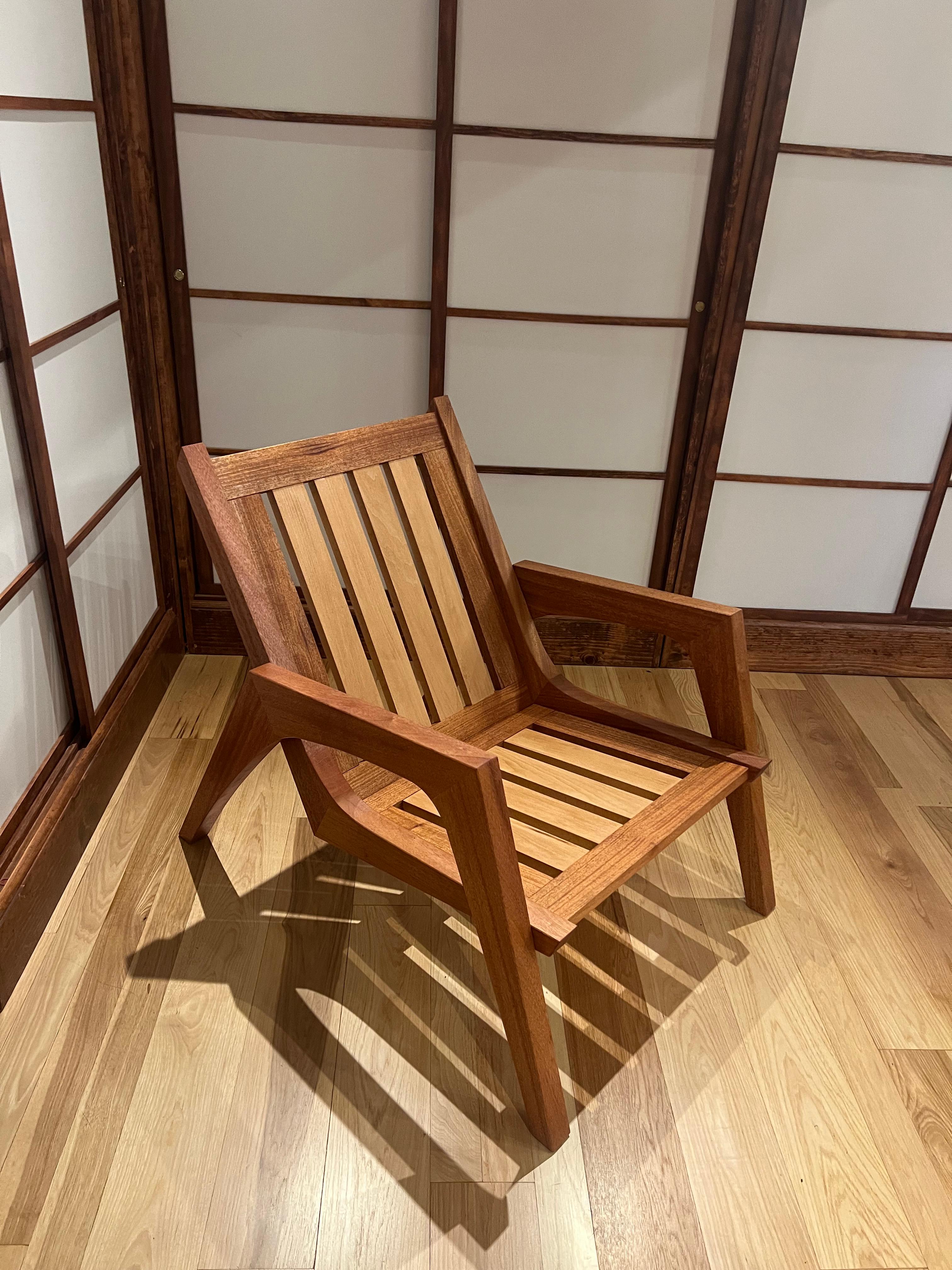 Finished mahogany and beech mid-century modern lounge chair, photographed against a shoji screen.