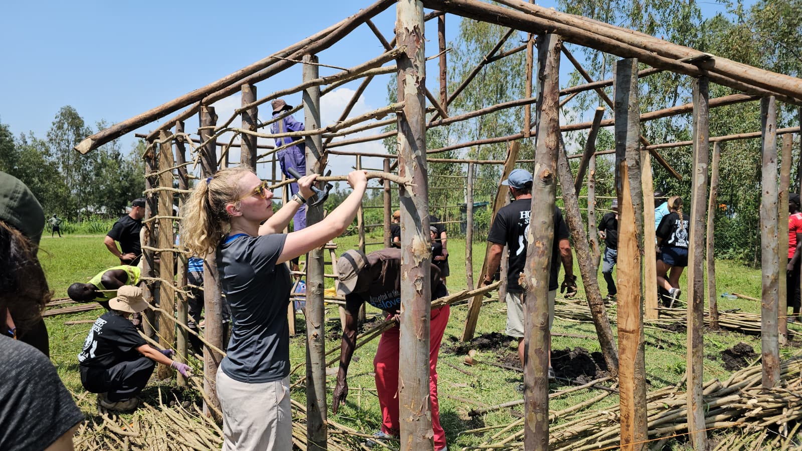 Maggie Coleman helping secure a timber frame lattice on site during construction