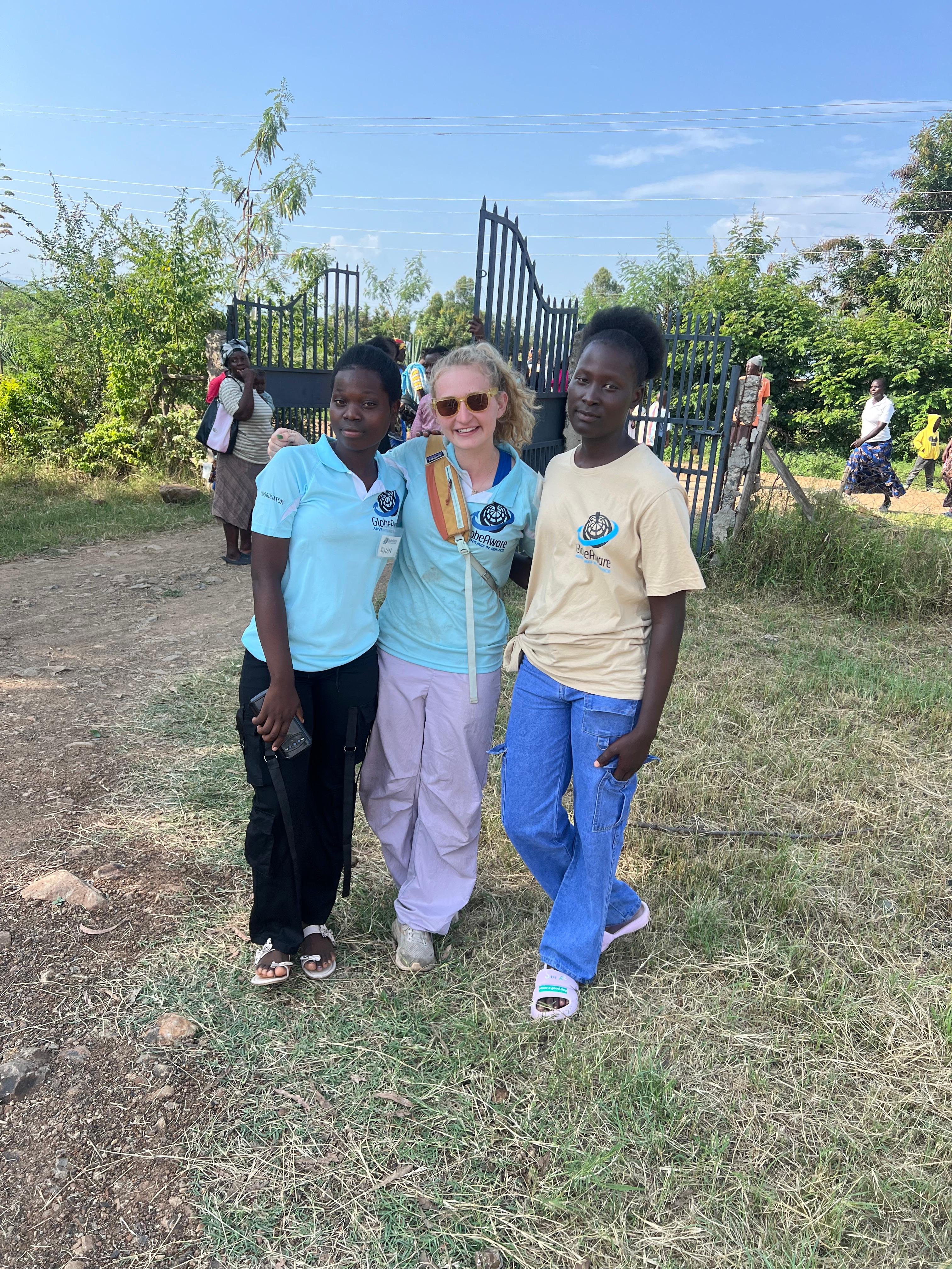Maggie Coleman with two local GlobeAware coordinators at the project site gate